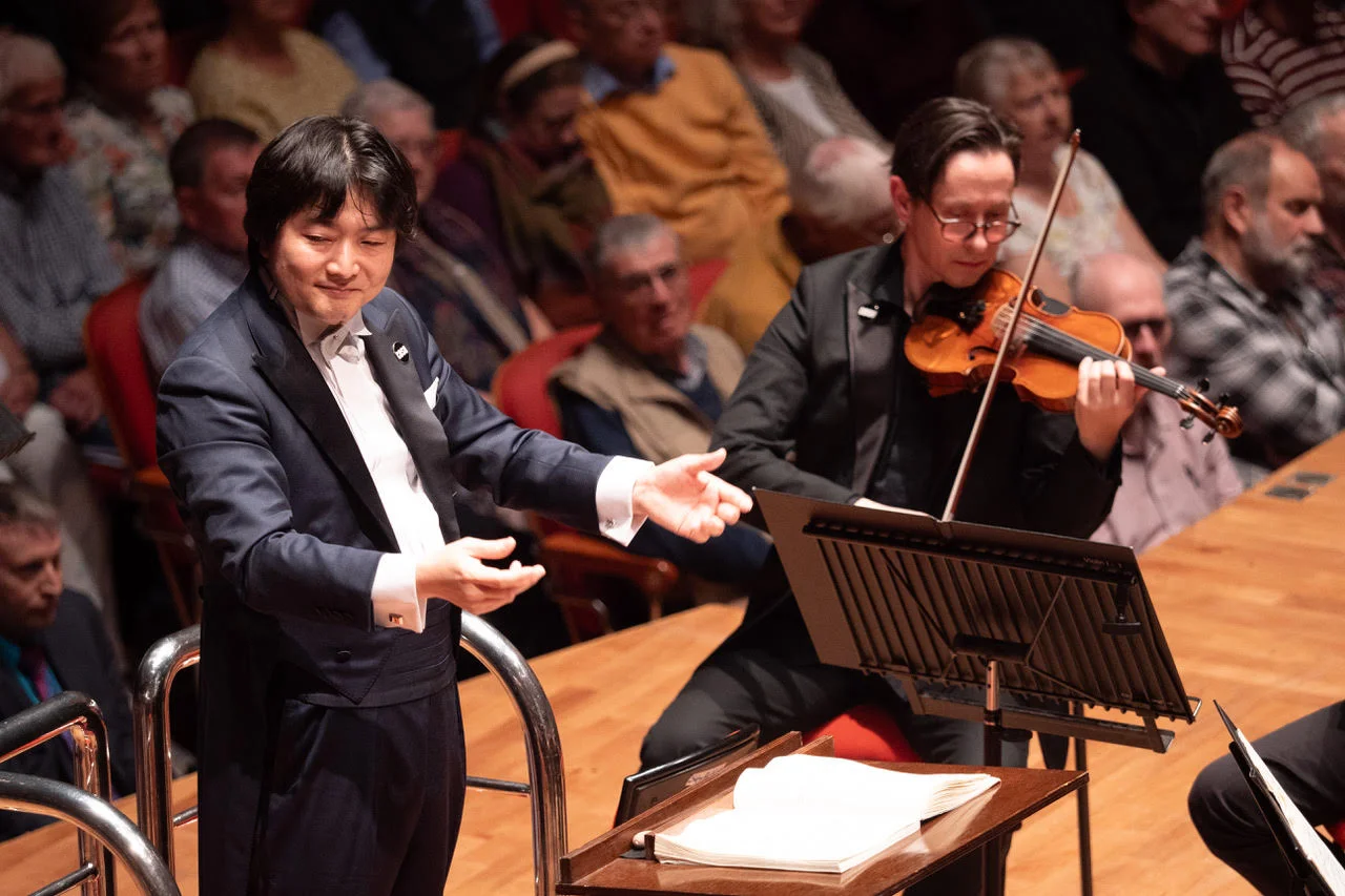 Kazuki Yamada conducts beside a CBSO violinist at Symphony Hall.